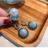 Set aus Ohrringen und Ringen mit großen weißen Perlen aus grünem Edelstein STB002